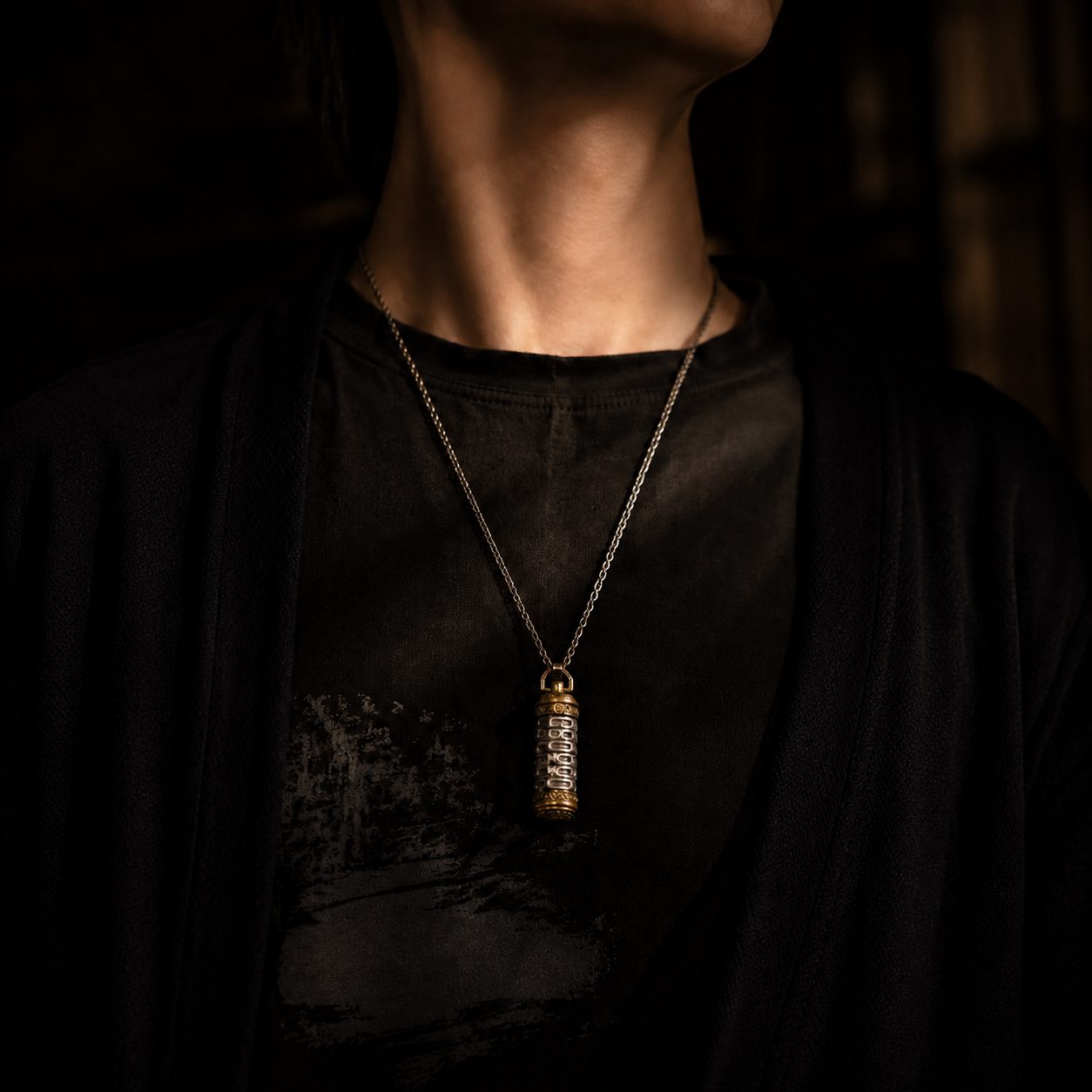 Revolving Mantra pendant necklace worn against a dark t-shirt, showing actual wearable size and everyday styling